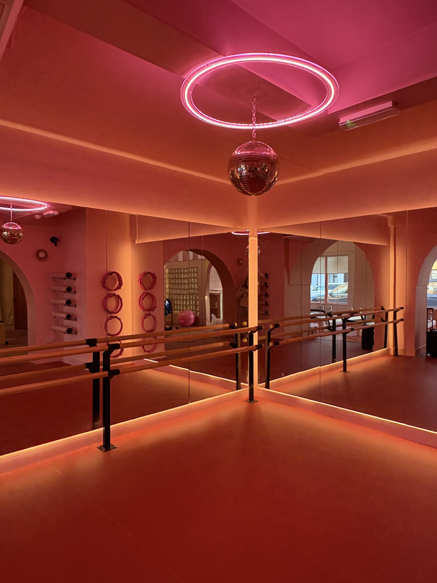 Øra barre and dance studio with pink lighting and a disco ball